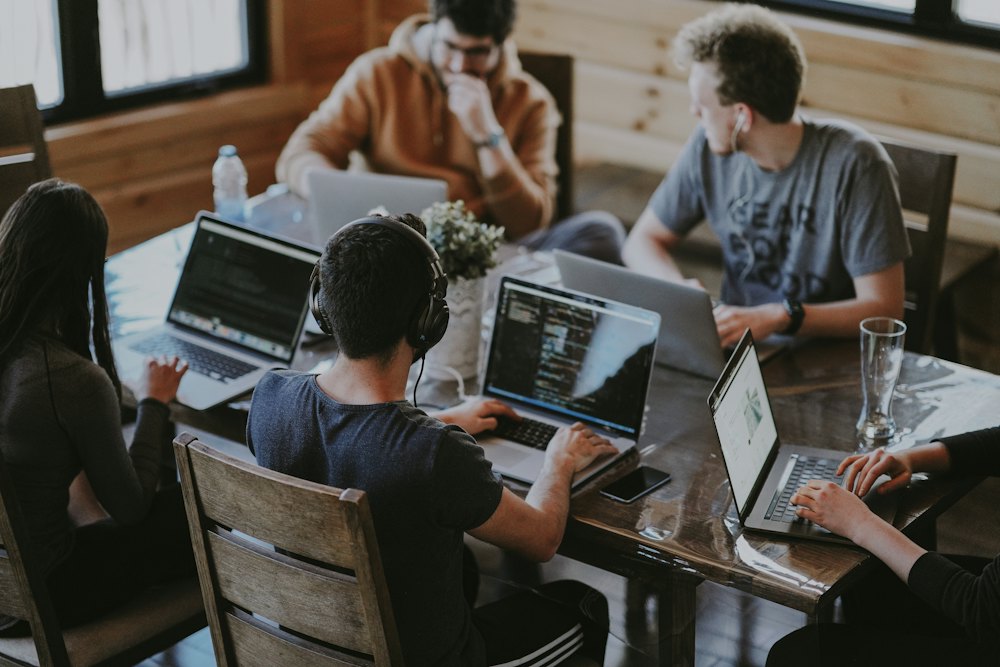 Software team collaborating on laptops around a table